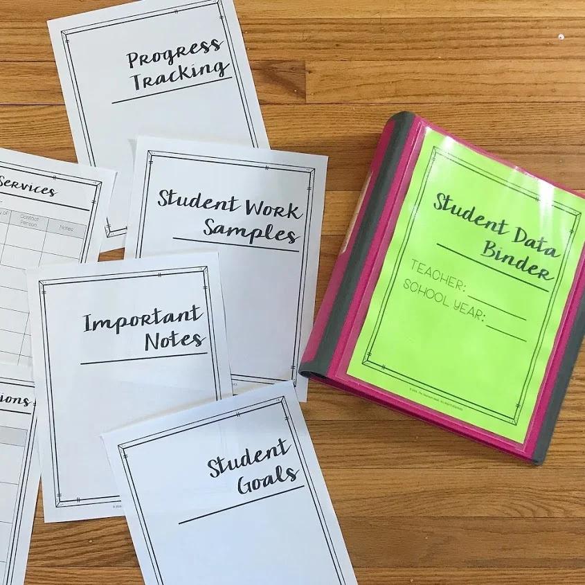 Collection of educational binders and sheets on a wooden surface